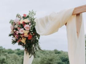 Foto de flores colgando de un arco adornado para una boda