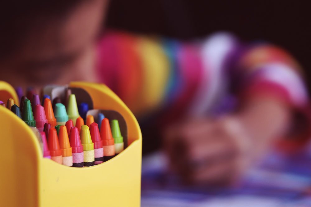 Foto de niño pintando con lapices de colores