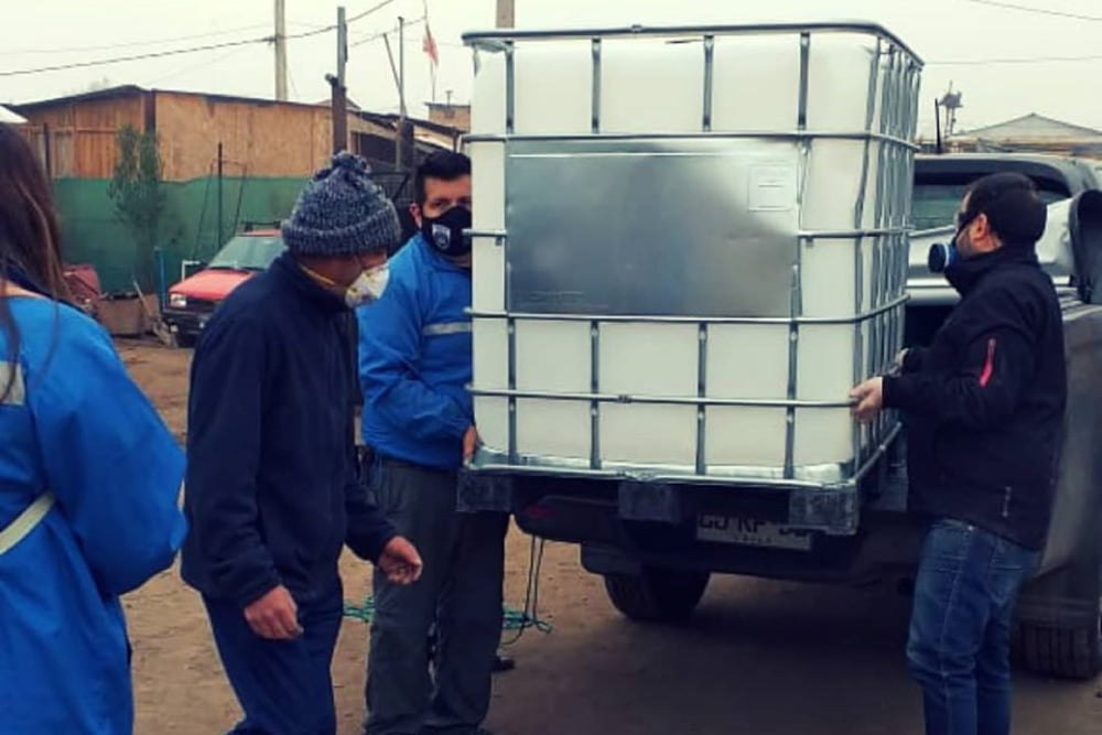 Foto de personas realizando entrega de amonio cuaternario en asentamiento millantun de puente alto