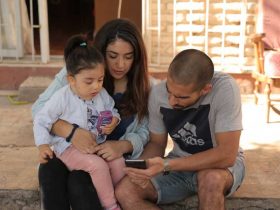 Foto de una familia, dos personas adultas y una niña de 4 años