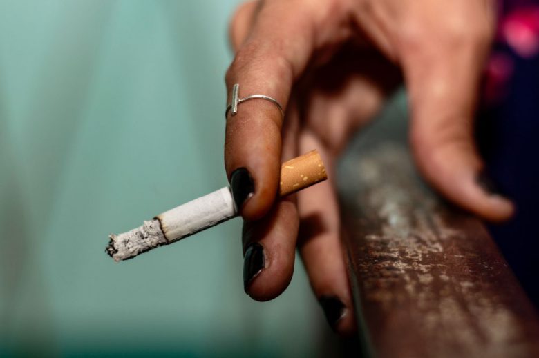 Persona sosteniendo un cigarrillo, portada de noticia en Somos Puente Alto