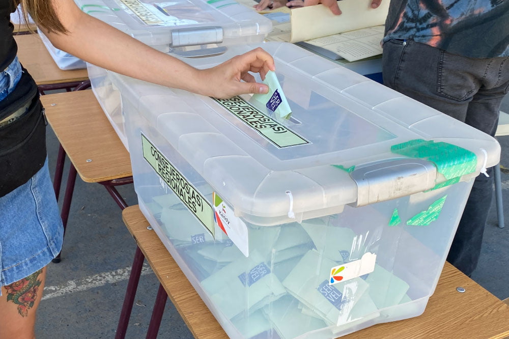 Foto de persona depositando voto en urna electoral