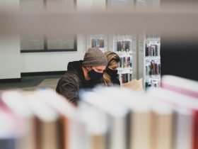 Foto de dos estudiantes leyendo en una biblioteca