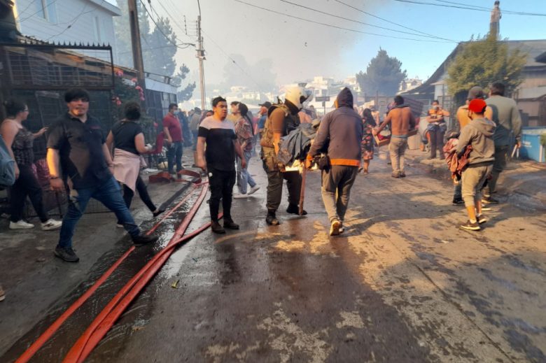 Foto de personas y bomberos en incendio de castro