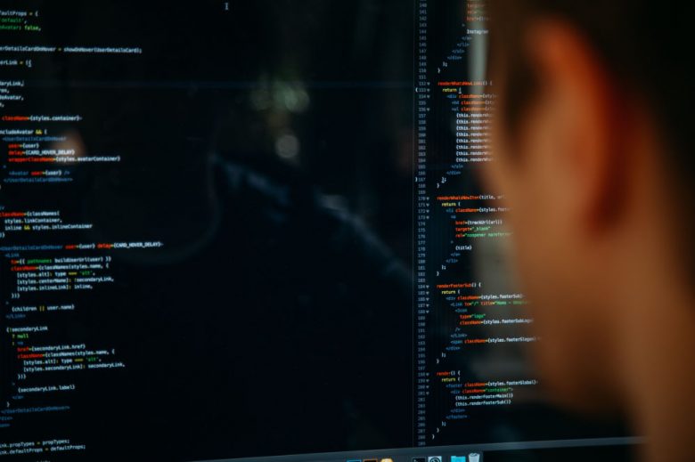 Foto de persona mirando la pantalla de un computador con códigos