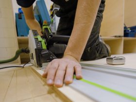 Foto de persona utilizando una sierra eléctrica para cortar madera