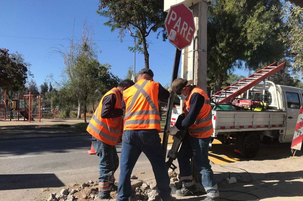 Foto de personas reparando un disco con señalética pare