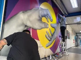 Foto de grafiteros de 1ko pintando mural en cesfam karol wojtyla