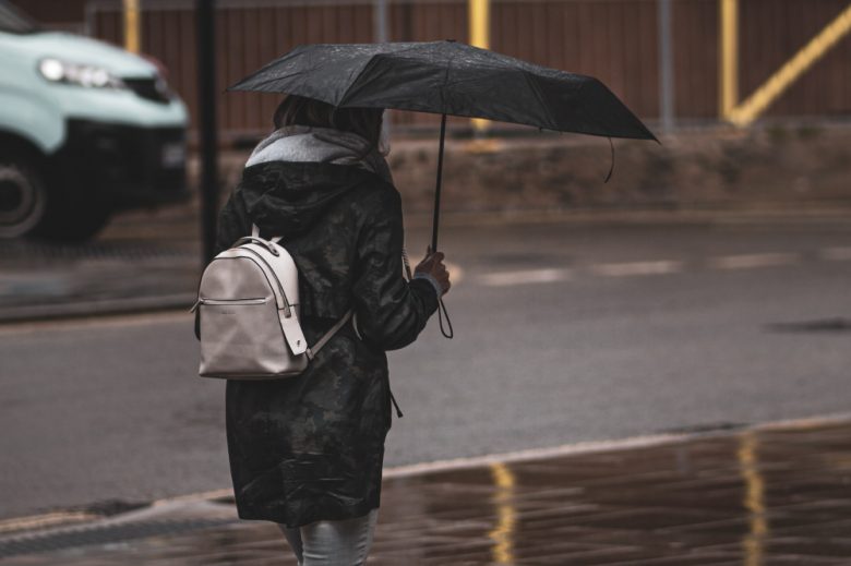 Foto de persona caminando con paraguas