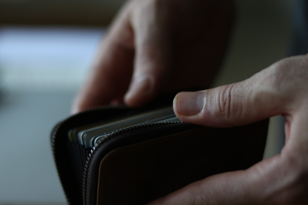 Foto de persona revisando billetera con tarjetas