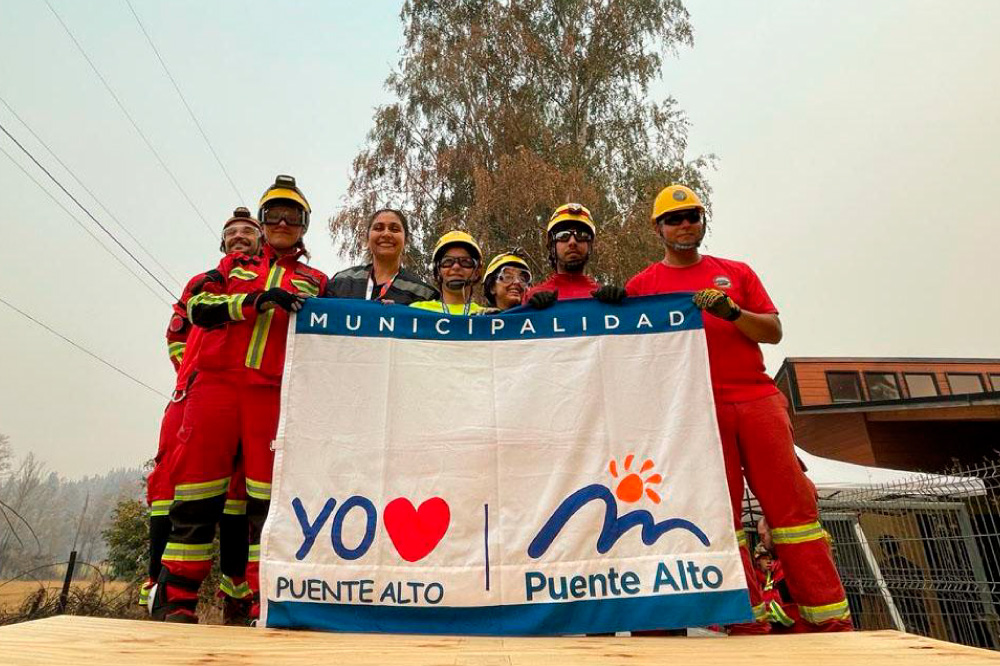 Foto de voluntarios sosteniendo una bandera de Puente Alto